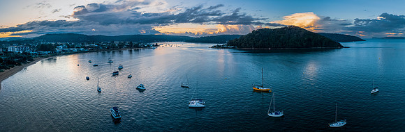 Aerial sunrise waterscape panorama with scattered rain clouds an