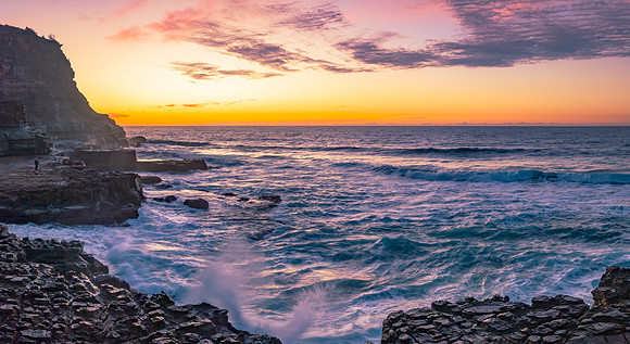 Ocean sunrise with rock platform and clouds
