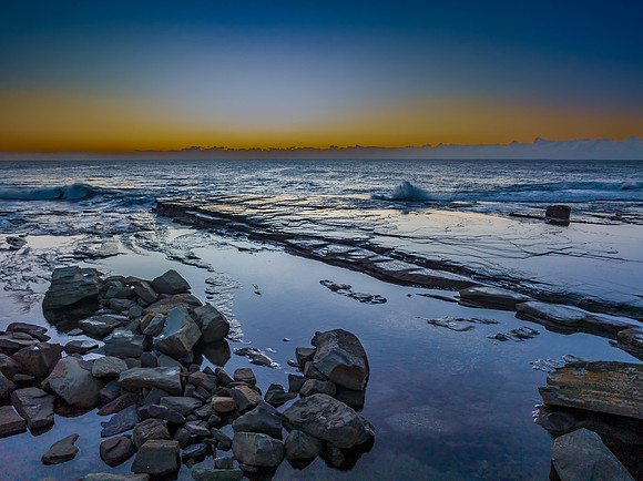 Sunrise over the sea and rocky Inlet with clear skies and a low
