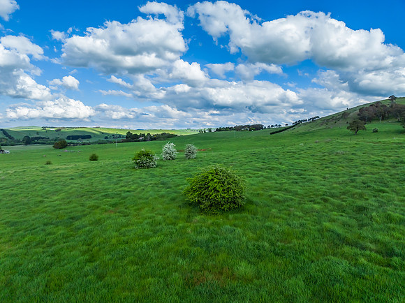 Afternoon aerial views over the green countryside with clouds in