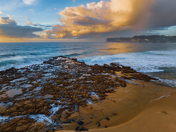 Sunrise and clouds over the ocean and rock platform