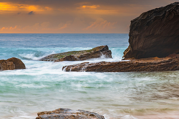 Sunrise at the seaside with rocks and beautiful diffused light b