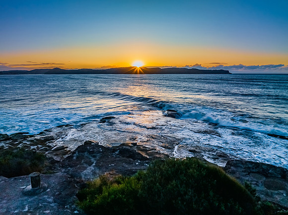 Aerial sunrise over the sea from the headland