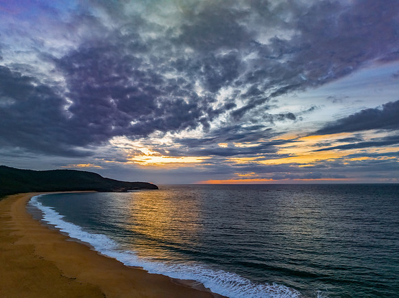 Sunrise seascape with clouds and gentle surf