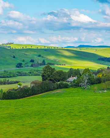 Afternoon aerial views over the green countryside with clouds in