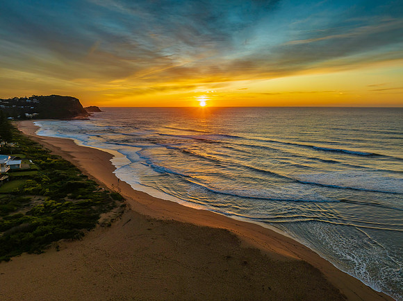 Sunrise and high cloud cover by the sea and lagoon