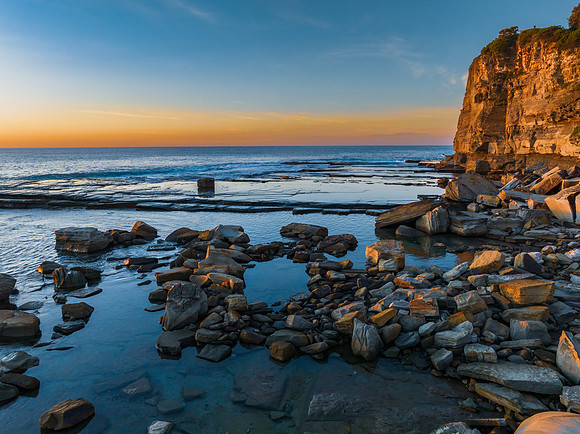 Sunrise over the calm sea and rocky Inlet