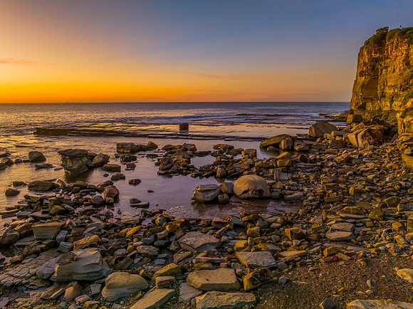 Sunrise over the calm sea and rocky Inlet