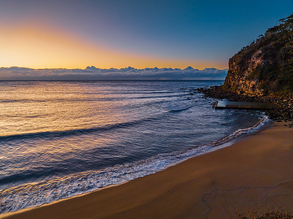 Sunrise at the seaside with low cloud bank and sea pool
