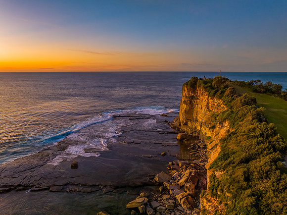 Sunrise over the calm sea and rocky Inlet