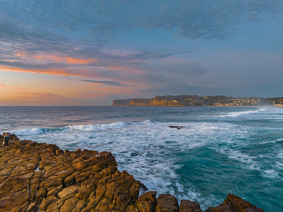 Ocean sunrise with rock platform and clouds