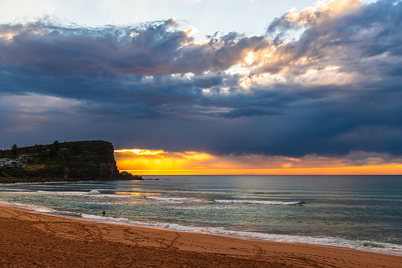 Winter sunrise by the sea shore with rain clouds