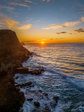 Ocean sunrise with rock platform and clouds