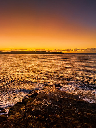 Aerial sunrise over the sea from the headland
