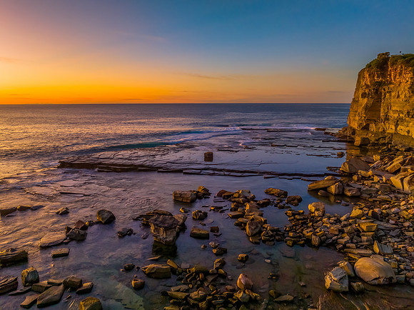 Sunrise over the calm sea and rocky Inlet