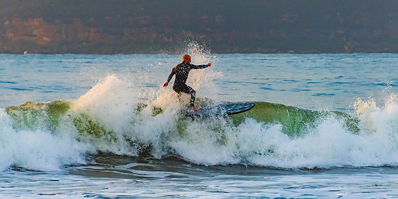 Sunrise surfer catching a wave