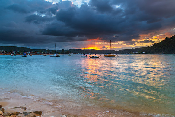 Overcast sunrise waterscape at the channel with boats
