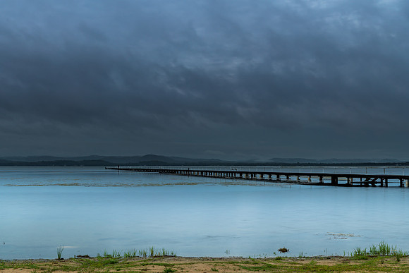 Rainy day sunrise waterscape with wharf