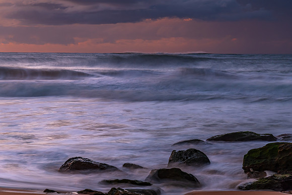 Sunrise seascape with low clouds and waves