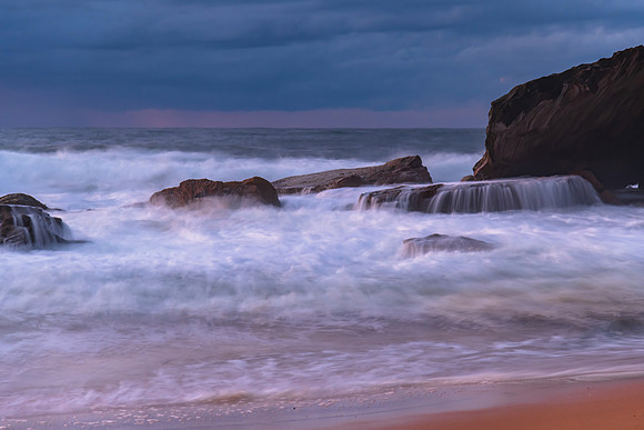 Sunrise seascape with low clouds and waves