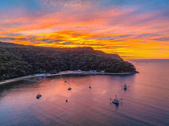 Sunrise over the bay with boats and cloud covered sky