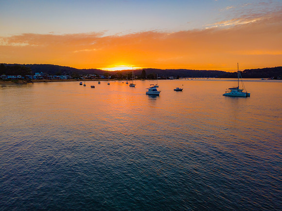 Aerial sunrise waterscape over the channel with orange clouds an