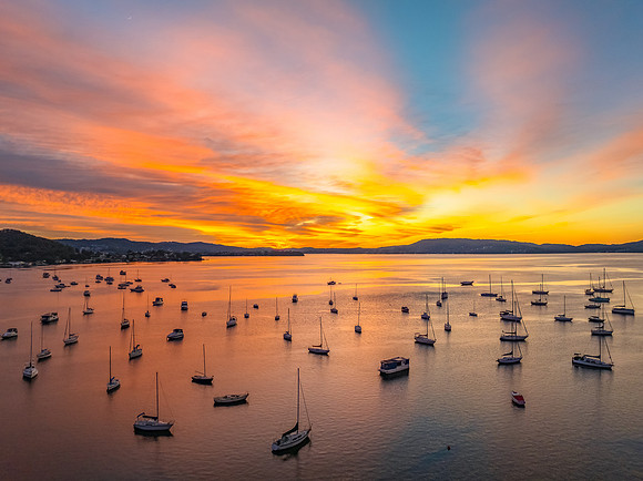 Aerial sunrise waterscape with boats and high cloud