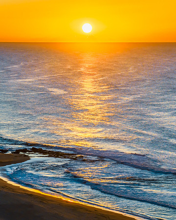 Summer sunrise at the seaside with clouds and haze