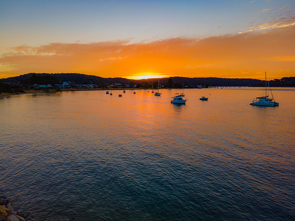 Aerial sunrise waterscape over the channel with orange clouds an