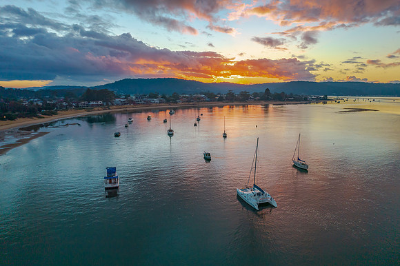 Aerial sunrise waterscape with boats and cloud cover