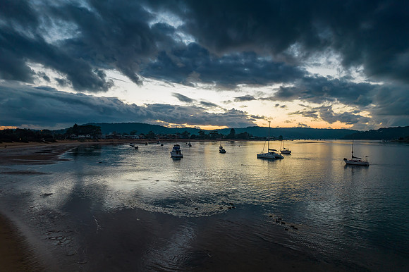 Aerial sunrise waterscape with boats and cloud cover