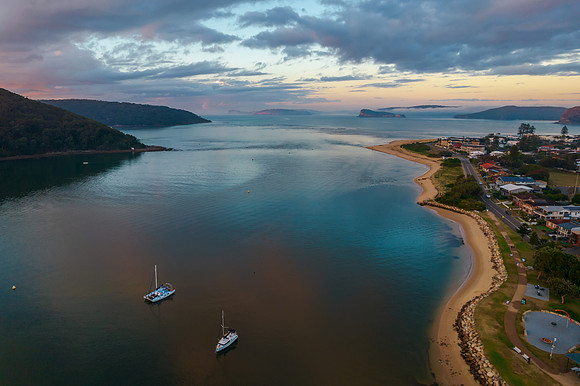Aerial sunrise waterscape with boats and cloud cover