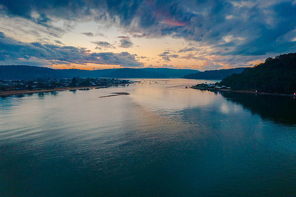 Aerial sunrise waterscape with boats and cloud cover