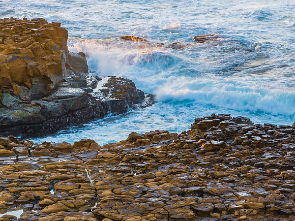 Ocean sunrise with rock platform and clouds