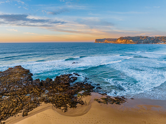 Ocean sunrise with rock platform and clouds