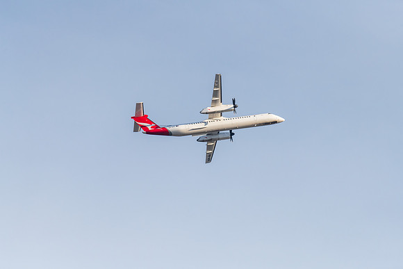 Airplane flying in blue sky with whispy white cloud