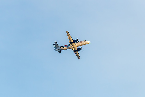 REX airplane flying in pale blue sky