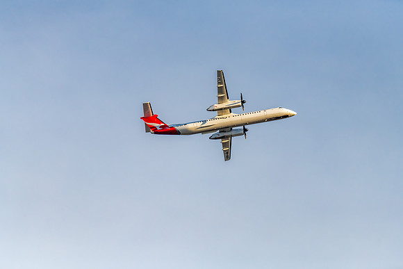 Airplane flying in blue sky with whispy white cloud