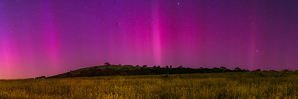 Aurora Australis display lights up the predawn sky in pinks