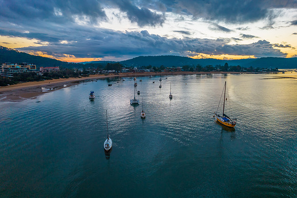 Aerial sunrise waterscape with boats and cloud cover