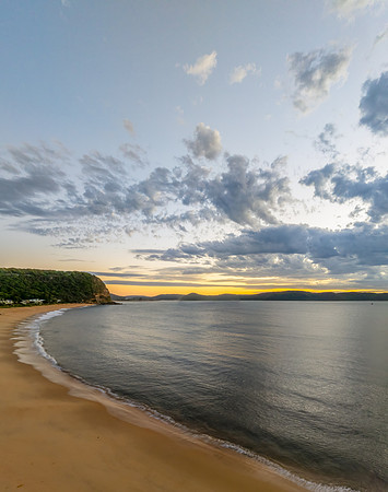 Sunrise over the ocean with clouds and a calm sea