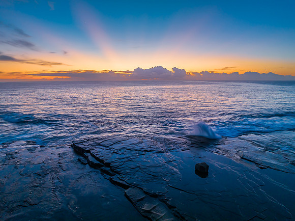 Sunrise over the blue sea and rocky Inlet