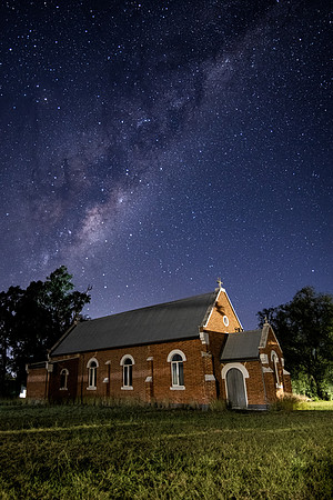 In the dark of the night a church situated under the milky way s