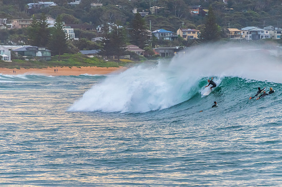 Early morning seascape with surfer catching a wave