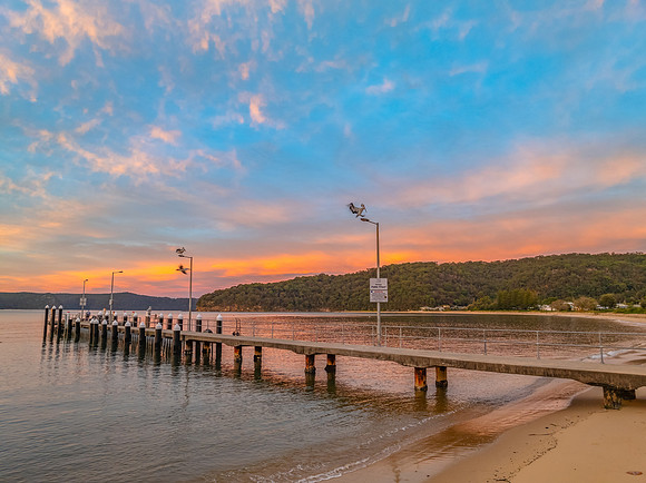 Sunrise over the bay with boats and cloud covered sky