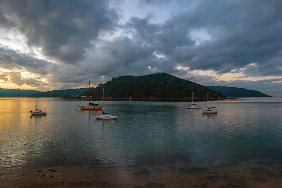 Aerial sunrise waterscape with boats and cloud cover
