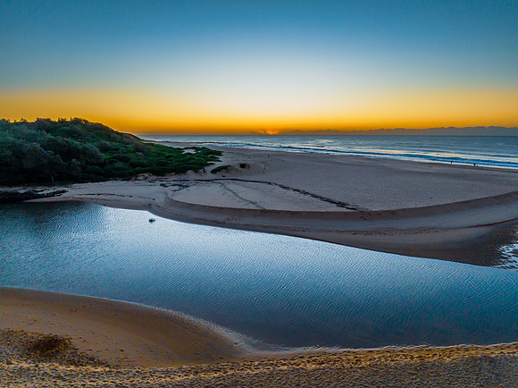 Summer sunrise at the seaside with clouds and haze