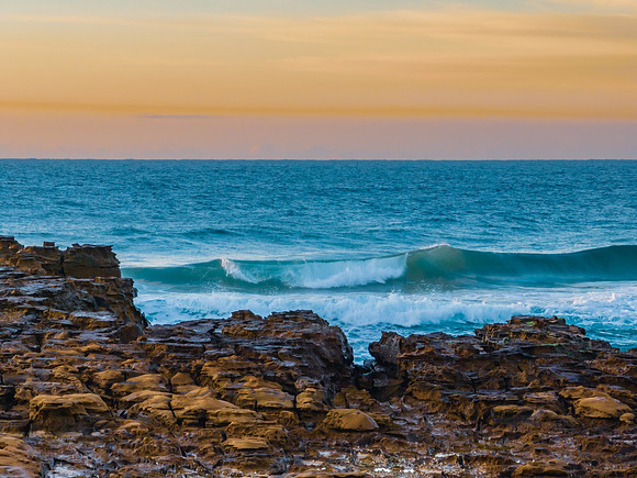 Ocean sunrise with wave amd pastel coloured sky