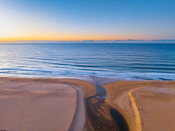 Summer sunrise at the seaside with clouds and haze