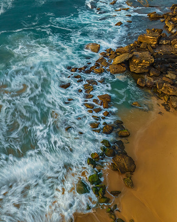 Surf, sea, sand, rocks, sunrise at the beach